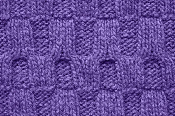 Ultra violet colored knitted texture with a relief pattern. Handmade Knitwear. Background, abstract. Color of the year 2019 concept