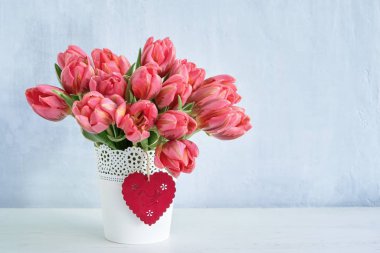 Pembe lale buketi beyaz Vazoda Kırmızı kalp ile dekore edilmiştir. Sevgililer günü, anneler günü kutlama kavramı. Kopya alanı