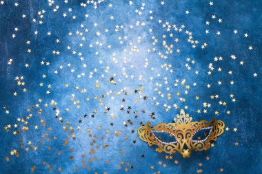 Altın Karnaval maskesi ve mavi zemin üzerine altın yıldız. En iyi VI