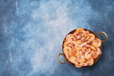 Mavi arka planda bir Vintage çanak üzerinde pişmiş taze karidesler. Polis