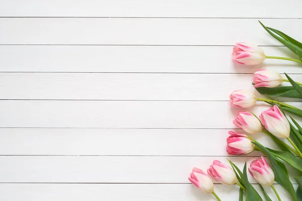 Rosa Tulpenstrauß auf weißem Holzhintergrund. Ansicht von oben, Kopierraum. Grußkarte. — Stockfoto
