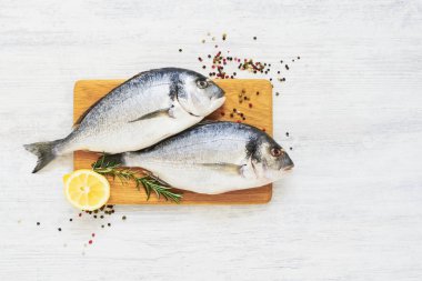 Ahşap kesme tahtasında baharatlarla ham taze Dorada balığı. Sağlık