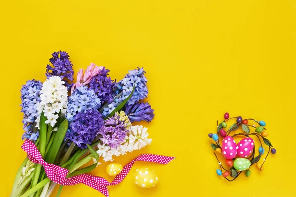 Gelber Osterhintergrund. Frühlingsblumen und dekorative Ostereier — Stockfoto