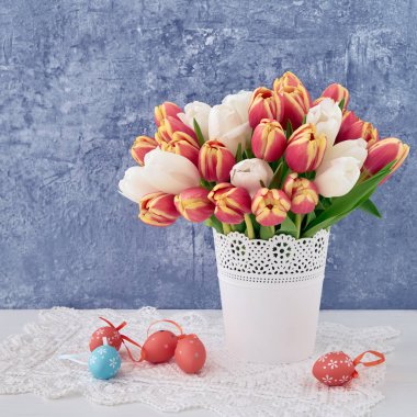 Paskalya geçmişi. Vazo içinde dekoratif Paskalya yumurtası ve kırmızı lale