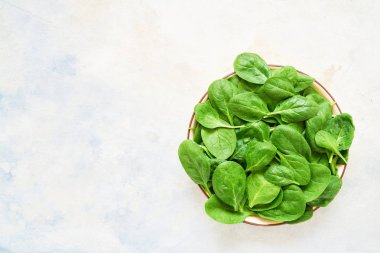 Taze ıspanak üzerinde beyaz tabak bırakır. Sağlıklı vegan gıda. Top vie