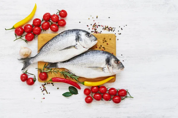 Peixe dorada fresco com especiarias em tábua de corte de madeira. Saudável — Fotografia de Stock