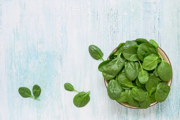 Fresh spinach leaves on white plate. Healthy vegan food. Top vie — Stock Photo, Image