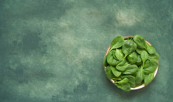 Fresh spinach leaves on white plate. Healthy vegan food. Top vie — Stock Photo, Image