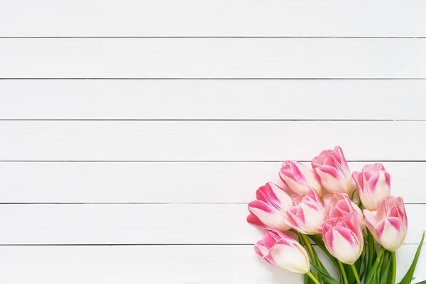 Bouquet de tulipes roses sur fond de bois blanc. Vue du dessus, espace de copie. Carte de voeux . — Photo
