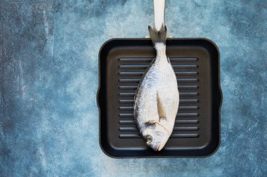 Mavi arka plan üzerinde taze pişmemiş dorado veya çipura balık. Üstte görüntü