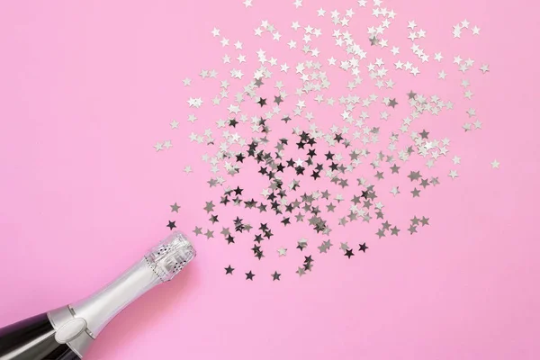 Parlak pembe arka planda konfeti yıldız şampanya şişesi. — Stok fotoğraf