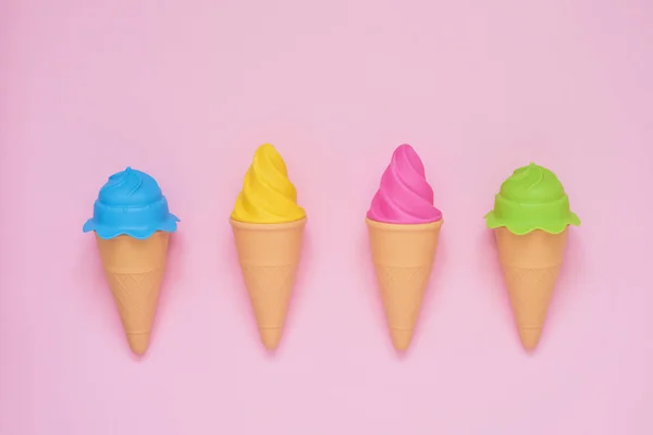 Vier bunte Spielzeug-Eis auf rosa Hintergrund. Sommerkonzept. — Stockfoto