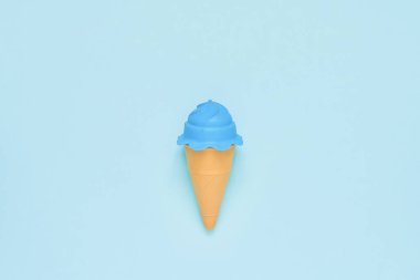 Lighn mavi arka plan üzerinde mavi oyuncak dondurma. Minimalizm, yaz 