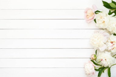 Ahşap arka planda beyaz şakayıklar. Boşluğu kopyala, üst görünüm.