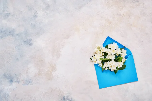 Philadelphus oder orangefarbene Blüten in blauem Umschlag. Geburtstag, Muttertag, Junggesellenabschied, Hochzeitskonzept. Kopierraum — Stockfoto