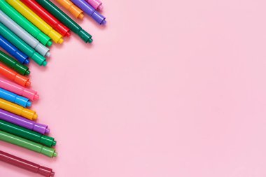 Metin yeri ile pembe arka plan üzerinde renkli keçeli kalem kenarlığı. Okul konseptine geri dönelim. Üst görünüm, kopyalama alanı