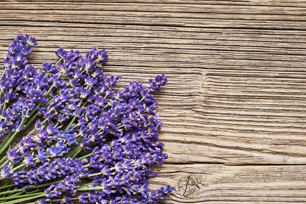 Lavender flowers bouquet on old wooden background. Copy space, top view