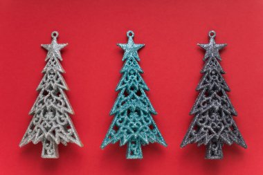 Noel dekorasyonu. Kırmızı zemin üzerinde Noel ağaçları. Noel tebrik kartı. Üst görünüm. Minimalizm