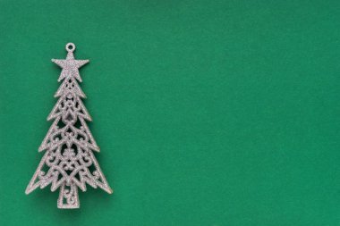 Noel dekorasyonu. Yeşil zemin üzerinde Noel ağacı. Noel tebrik kartı. Üst görünüm. Minimalizm