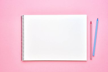 Kalemli spiral not defteri. Pastel pembe zeminüzerine not defteri. Okul konseptine geri dönelim. Kopya alanı, üst görünüm.