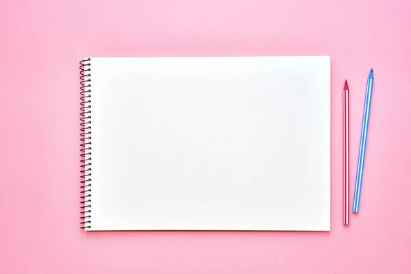 Spirálový Poznámkový blok s tužkami. Notebook na pastelově růžovém pozadí. Zpátky do školy. Kopírovat prostor, pohled shora. — Stock fotografie