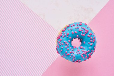 Serpilmiş Mavi Donut. Renkli pembe arka plan üzerine sırlı serpiştirilmiş çörek. Üst görünüm, kopyalama alanı. 