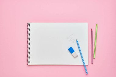 Kalemli spiral not defteri. Pastel pembe zeminüzerine not defteri. Okul konseptine geri dönelim. Kopya alanı, üst görünüm.