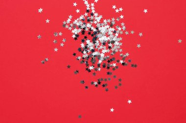 Kırmızı Noel geçmişi. Kırmızı zeminde konfeti yıldızları. Üst görünüm, kopyalama alanı. Minimalizm