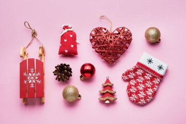 Pembe arka planda Noel süsleri olan düz bir kompozisyon.