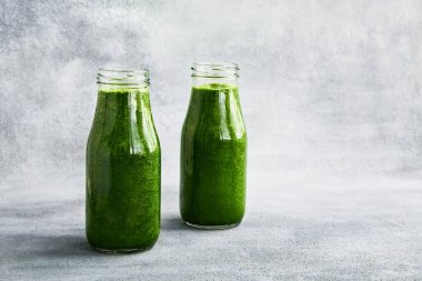 Gri arka planda ıspanaklı yeşil smoothie. Uzayı metin için kopyala. Sağlıklı gıda konsepti