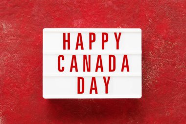 Kırmızı arka planda ışık kutusuyla yazılmış Mutlu Kanada Günleri. Bağımsızlık Günü tarihi. Üst görünüm, alanı kopyala