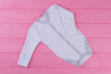 Yeni yumuşak uzun kollu romper bebek için. Beyaz desenli gömlek pembe arka plan, üstten görünüm üzerinde yeni doğan çocuk için. Bebekler için giysi.