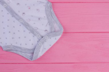 Düğmeli gömlek bebekler, kırpılmış görüntü için. Yeni pamuk yaz bebek pembe ahşap arka plan ve kopya alanı için jumsuit.