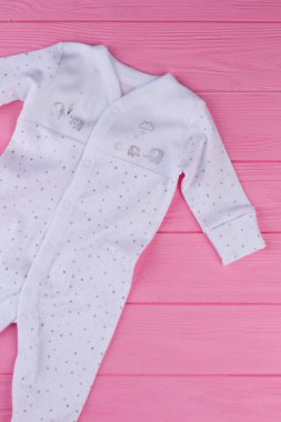 Yeni doğan bebek beyaz uyku takım. Üstten görünüm üzerinde bebek kız, pembe arka plan için marka organik giyerlerdi. Çocuk için yüksek kaliteli kıyafet.