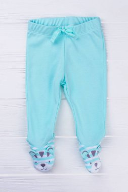 Çocuklar için mavi ayaklı pantolon. Beyaz tahta arka plan.