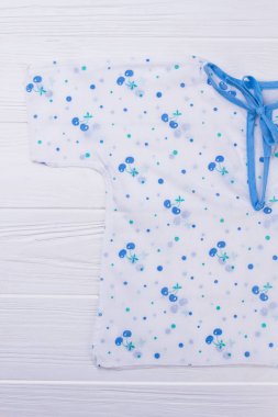 Gömlek yay ile yeni doğan için. Beyaz ahşap zemin.