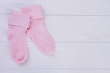 Woolean çifti Bebek çorap boşaltmak ile pembe. Beyaz ahşap zemin.