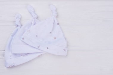 Beyaz şapka koleksiyonu, üstten görünüm. Thre bebek şapkalar ahşap arka planda.