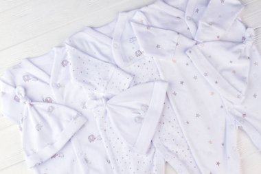 Pijama pijama düğüm şapkalı beyaz bebek çocuklar için. Beyaz tahta arka plan.