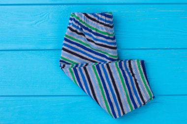 Çizgili şort tahtaya bükülmüş. Mavi arka plan bebek toddler pantolon.