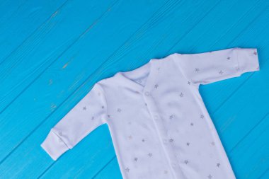 Beyaz pijama yazdırılan yıldız olan çocuklar için. Üstten görünüm. Mavi ahşap arka plan.