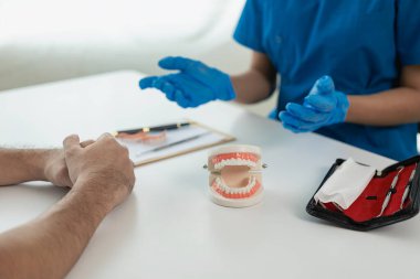 Adam dişçi kliniğinde dişçi muayenesinden geçiyor. Diş sağlığınızı kontrol edin ve uzaktan Moel diş hekiminden oral bakım tavsiyesi alın.
