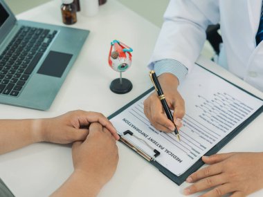 Bir göz doktoru, erkek hastanın zayıf görüşünü göz küresi ve gözlüklerinin bir maketi ile nasıl düzelteceğini tartışıyor..