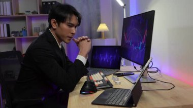 Bir erkek işadamı bilgisayar ekranına bakarak hisse senedi fiyatlarının düşüşünü gösteriyor, dizüstü bilgisayarındaki borsanın çöküşünü izlerken strese giriyor, borsa çöküşü hakkında strese giriyor..