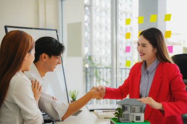 Kağıt işleri ve gülümseme ile işi bitiriyorum. Bir çift el sıkışır ve dairelerinin başarılı satışından dolayı emlakçıya teşekkür eder, sonra anlaşmayı tamamlar ve yeni evlerinin satın alınmasını kutlar..