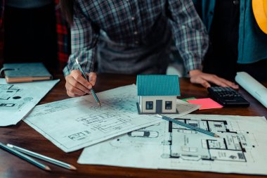 İnşaat alanı mimarları ve mühendislerinin bina planlarını ve inşaat standartlarını karşılama planlarını tartışmak ve kontrol etmek için bir araya geldikleri projeleri kontrol eden mimar.