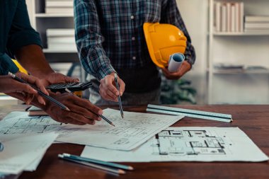 İnşaat alanı mimarları ve mühendislerinin bina planlarını ve inşaat standartlarını karşılama planlarını tartışmak ve kontrol etmek için bir araya geldikleri projeleri kontrol eden mimar.