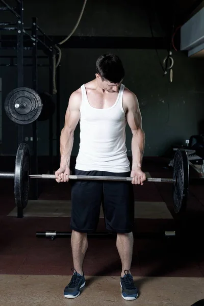 Close up of young muscular man lifting weights — Stock Photo, Image