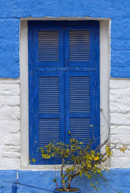 Fas 'ın tarihi merkezi Asilah' ta tarihi bir evin beyaz ve mavi penceresi.