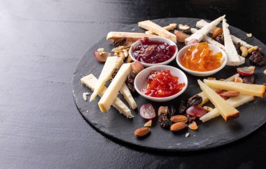 Siyah arka planda fındık ve marmelatlı peynir tahtası - gastronomi - gurme
